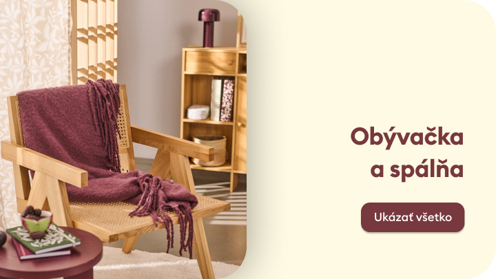 Kútik na relax v obývačke so štýlovým dreveným kreslom, regálom na uskladnenie a doplnkami. Atmosféra vyžaruje pohodlie a útulnosť. Vedľa obrázka je text 