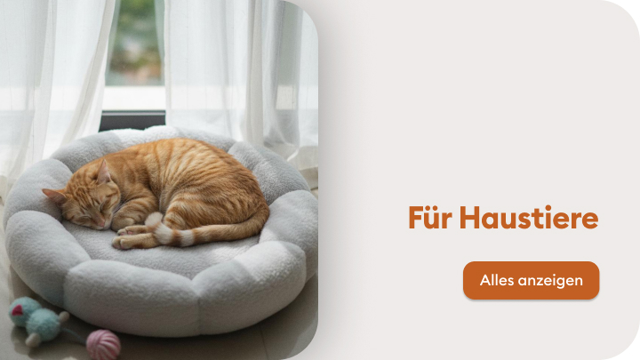 Gemütlich schlummernde Katze in einem weichen Haustierbett neben einem Spielzeug. Der Text "Für Haustiere" ergänzt mit einem Button "Alles anzeigen" lädt dazu ein, Produkte für Haustiere zu entdecken.