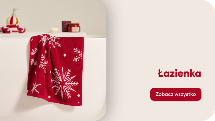 Czerwona świąteczna ściereczka z białymi wzorami w kształcie śnieżynek zawieszona na wannie w łazience. Obok widoczne są kosmetyki i akcesoria łazienkowe. Napis „Łazienka” oraz przycisk z tekstem „Zobacz wszystko” zaprasza do odkrycia świątecznych dekoracji łazienkowych.