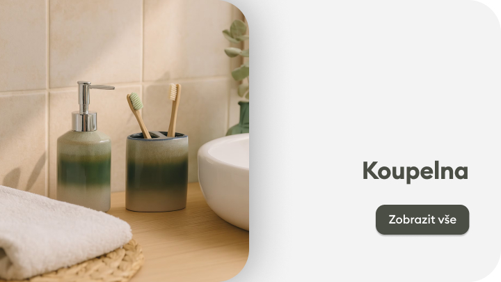 Moderní koupelna se stylovými doplňky. Na dřevěné desce je umyvadlo, kelímek na kartáčky a dávkovač mýdla. V popředí je složený ručník na pletené podložce. Vedle umyvadla stojí zelená rostlina. Tlačítko 