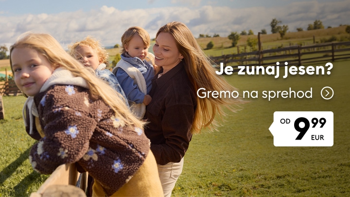 Družina z otroki na jesenskem sprehodu v naravi v toplih oblačilih za hladnejše dni.