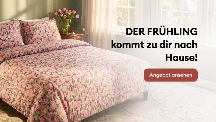 Frühlingshaftes Schlafzimmer mit Bettwäsche im Blumendesign. Text zeigt: "Der Frühling kommt zu dir nach Hause!" und lädt ein, das Angebot durch Klicken auf die Schaltfläche „Angebot ansehen“ zu entdecken.