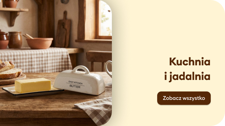 Stół w kuchni z masłem na talerzyku i pojemnikiem na masło. W tle inne elementy wyposażenia kuchennego i okno. Tekst obok: „Kuchnia i jadalnia”. Przycisk: „Zobacz wszystko”.