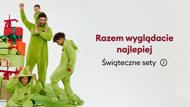 Grupa osób ubranych w świąteczne, zielone stroje, stojących obok stosu prezentów. Obok nich znajduje się napis: „Razem wyglądacie najlepiej. Świąteczne sety.” Tekst zachęca do zakupu zestawów tematycznych na święta. banner