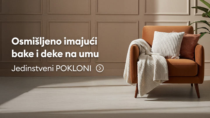 Promotivni tekst o jedinstvenim poklonima namenjenim bakama i dekama, prikazujući udobnu fotelju sa jastucima i prekrivačem. Poruka poziva korisnike da istraže ideje za pažljivo osmišljene darove koji pružaju udobnost i toplinu.