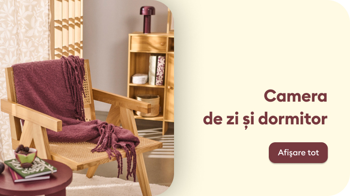 Imaginea prezintă o cameră decorată cu mobilier din lemn și elemente cozy, incluzând un fotoliu cu o pătură, o măsuță de cafea și o etajeră organizată. Spațiul este destinat relaxării și confortului. Mesajul de pe imagine indică „Camera de zi și dormitor” cu opțiunea „Afișare tot”. banner