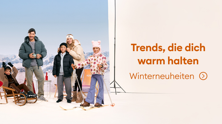 Gruppenbild von Personen in winterlicher Kleidung mit Wintersportausrüstung. Im Hintergrund sind Berge und Studiolichter zu sehen. Neben der Gruppe steht der Text: "Trends, die dich warm halten – Winterneuheiten". Ein Pfeil deutet auf weitere Informationen hin.