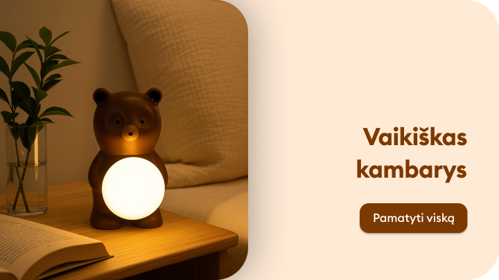 Vaikiško kambario detalė: naktinė lemputė meškos formos, švelniai apšviečianti stalą šalia lovos. Šalia lemputės padėta knyga, o foną sudaro augalas ir pagalvė. Tekstas šalia lemputės kviečia „Pamatyti viską“. banner