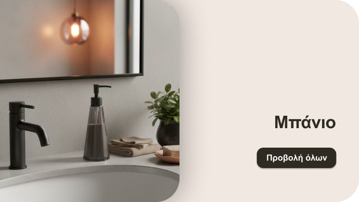 Μπάνιο με μοντέρνο νιπτήρα, μαύρη βρύση και σαπουνοθήκη στον πάγκο. Πλάι τους, τακτοποιημένες πετσέτες και διακοσμητικό φυτό. Ο καθρέφτης αντανακλά ένα ζεστό φωτιστικό στο βάθος.