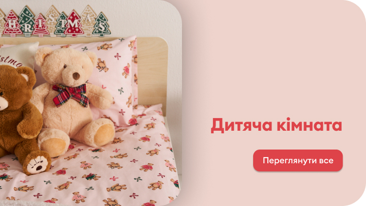 Два плюшеві ведмедики сидять на дитячому ліжку з постільною білизною, прикрашеною квітковим орнаментом. Над ліжком знаходяться декоративні дерев'яні прикраси у формі ялинок. Праворуч текст: 