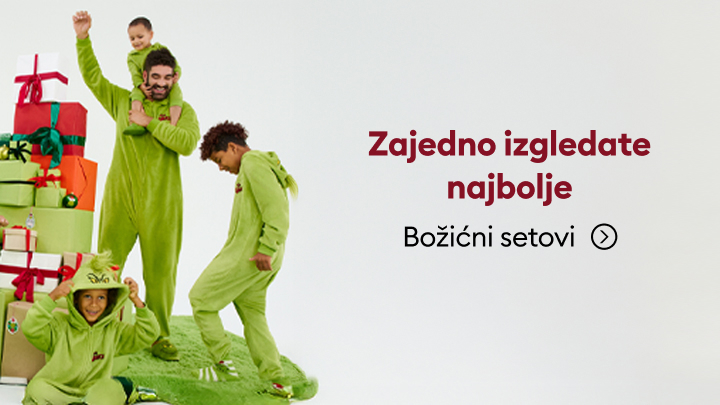 Grupa ljudi obučena u zelene praznične kostime stoji pored naslaganih poklona. Natpis poručuje: 