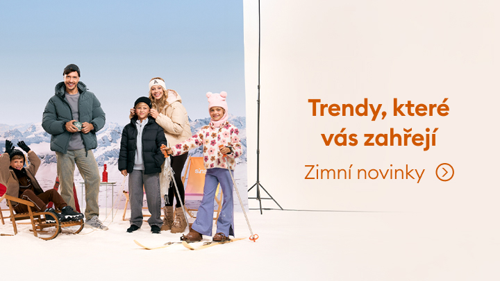 Obrázek zobrazuje scénu s rodinou v zimním prostředí a vybavením, jako jsou sáňky a lyže. Na pravé straně je nápis „Trendy, které vás zahřejí“ a odkaz na zimní novinky. Reklama láká na zimní oblečení a doplňky.
