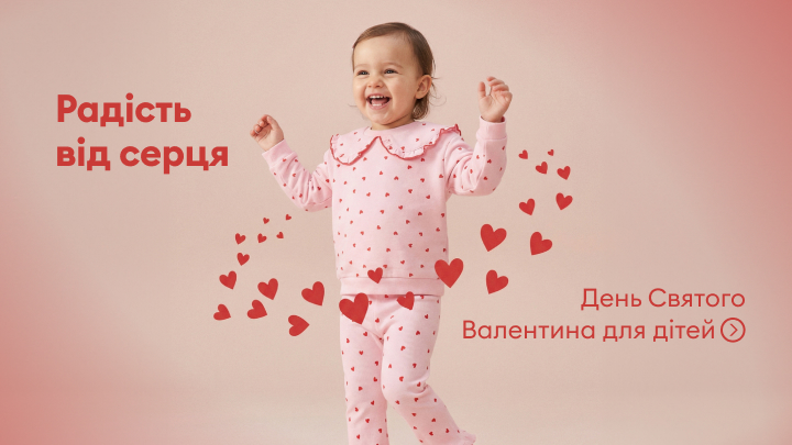 День Святого Валентина для дітей. Радість від серця – зображення показує дитину в піжамі з сердечками. Оточена маленькими червоними серцями, які створюють веселу та теплу атмосферу. Святковий контекст присвячений любові і щастю для малечі.