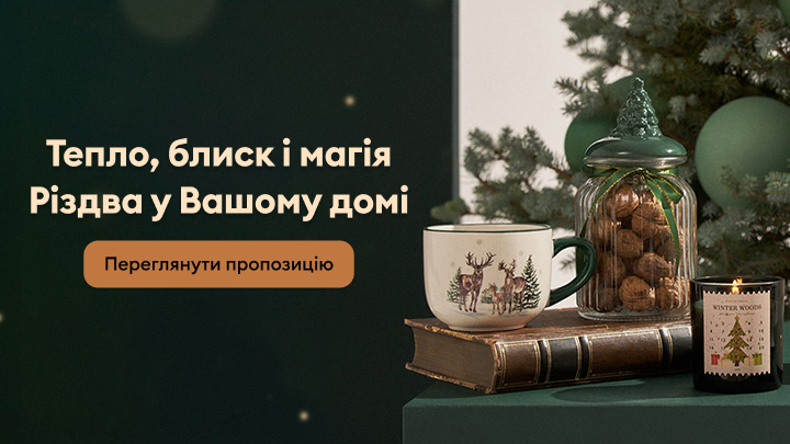 Тепло, блиск і магія Різдва у вашому домі. На зображенні представлені різдвяні аксесуари: свічка, горіхи у скляній банці, чашка із зображенням оленів та книга. Кнопка закликає переглянути пропозицію святкових товарів для вашого затишного дому.