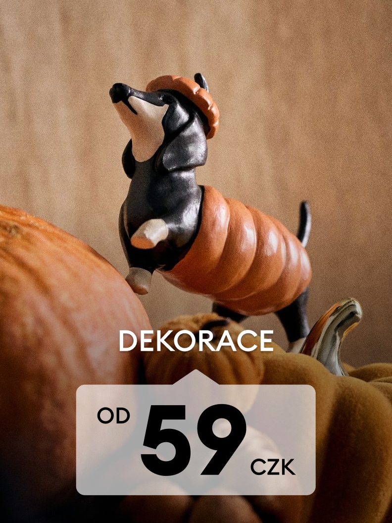 Podzimní dekorace s figurkou jezevčíka v dýňovém kostýmu mezi dýněmi, vhodné pro sezónní výzdobu domácnosti.