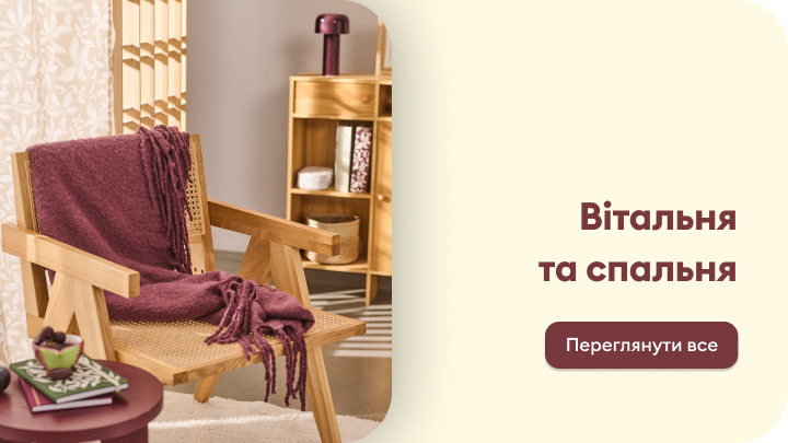 Меблі для вітальні та спальні з акцентом на комфорт і стиль. На передньому плані затишне крісло з пледом, поруч невеликий столик із декором. На задньому плані дерев'яна шафа з полиціями для зберігання предметів. Кнопка з текстом 