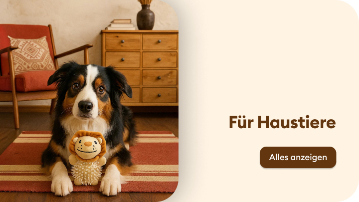 Hund liegt auf einem gestreiften Teppich in einem gemütlich eingerichteten Wohnzimmer und hält ein Spielzeug in Form eines Löwen. Text auf der rechten Seite des Bildes: „Für Haustiere“ mit einem Button darunter „Alles anzeigen“. Das Bild bewirbt Produkte für Haustiere. banner
