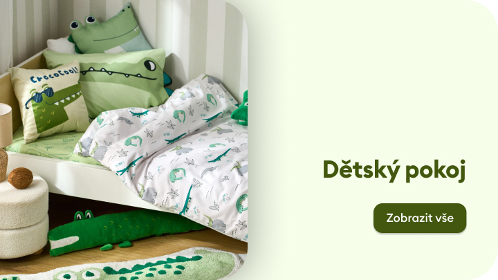 Dětský pokoj s motivem krokodýlů. Postel s polštáři a přikrývkou zdobenou krokodýlími ilustracemi. Plyšové hračky a dekorace s krokodýlí tématikou na podlaze. Klidné a hravé prostředí pro děti. Odkaz na více produktů.