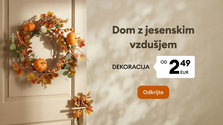 Jesenska dekoracija za dom z venčkom in sezonskimi okraski za ustvarjanje prijetnega vzdušja.