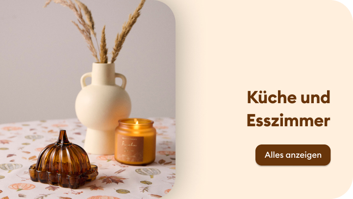 Dekorative Tischdekoration für Küche und Esszimmer: eine beigefarbene Vase mit getrockneten Gräsern, ein bernsteinfarbener Glasbehälter und eine brennende Duftkerze. Text auf der rechten Seite: „Küche und Esszimmer“, darunter ein Button mit der Aufschrift „Alles anzeigen“. banner